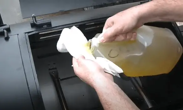 Oiling interior of the grill using paper towel and veg oil